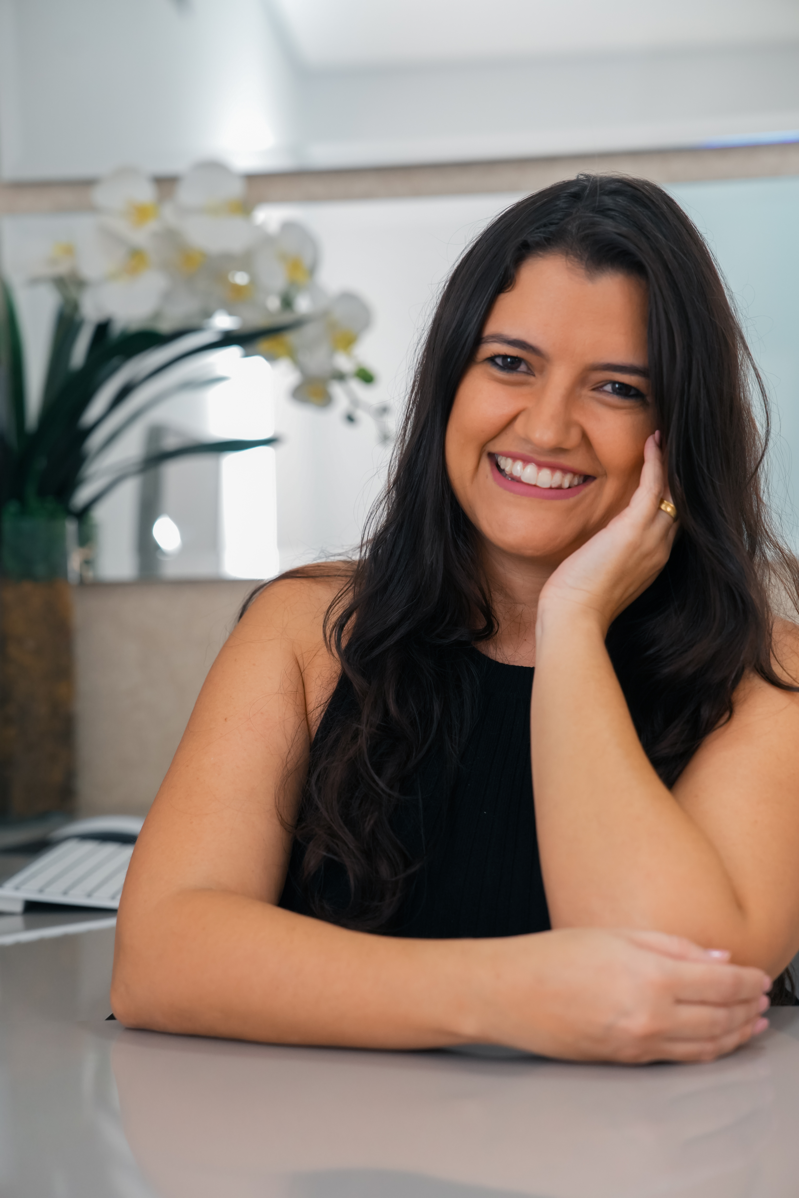 Foto da psicóloga Patrícia Delfino, sorrindo e acolhedora.